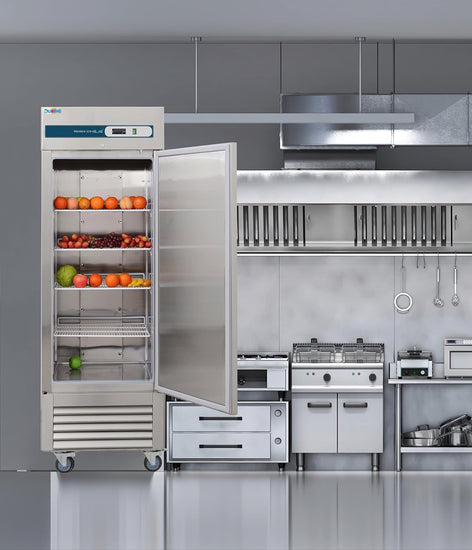 Commercial kitchen with stainless steel refrigerator and cooking equipment.