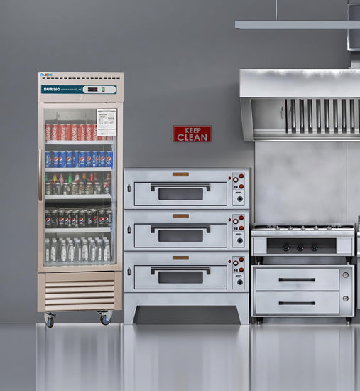 Commercial kitchen equipment including a refrigerator, ovens, and a stove against a gray wall with a 'Keep Clean' sign.
